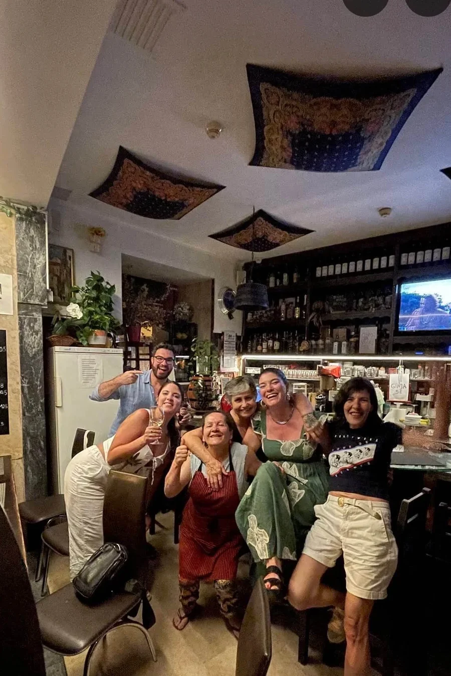 Petiscos, prato quente e dois copos de vinho em cima do balcão